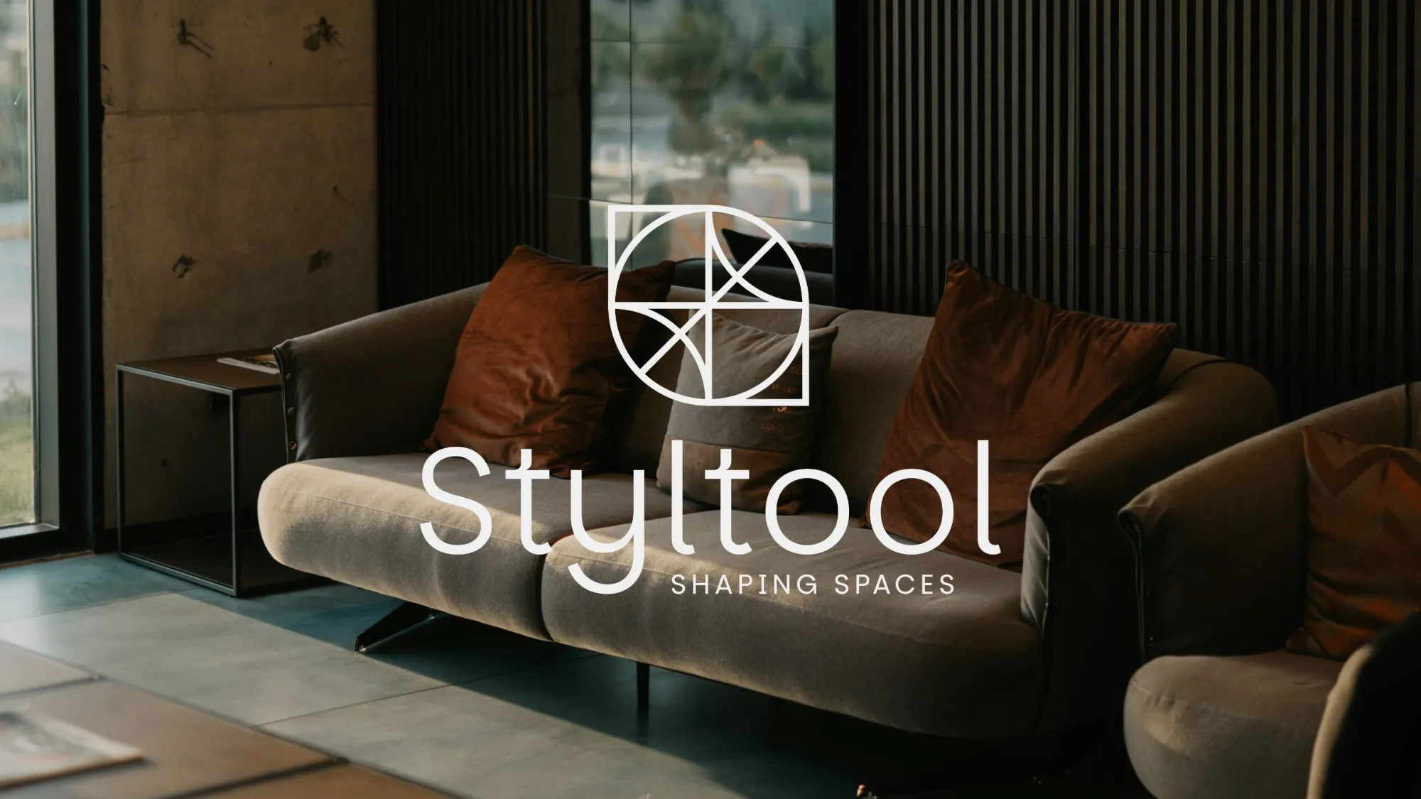 Styltool logo in white over a dark living room with a grey sofa and rust cushions